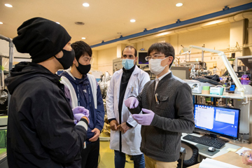 放射光施設内でディスカッションする松尾准教授と研究メンバー。学部や大学院の学生も施設内で実験を行っている。